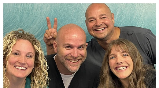 Chiropractor Louisville KY Shawn Martin Throwing Up a Peace Sign and Rick Simpson with Team